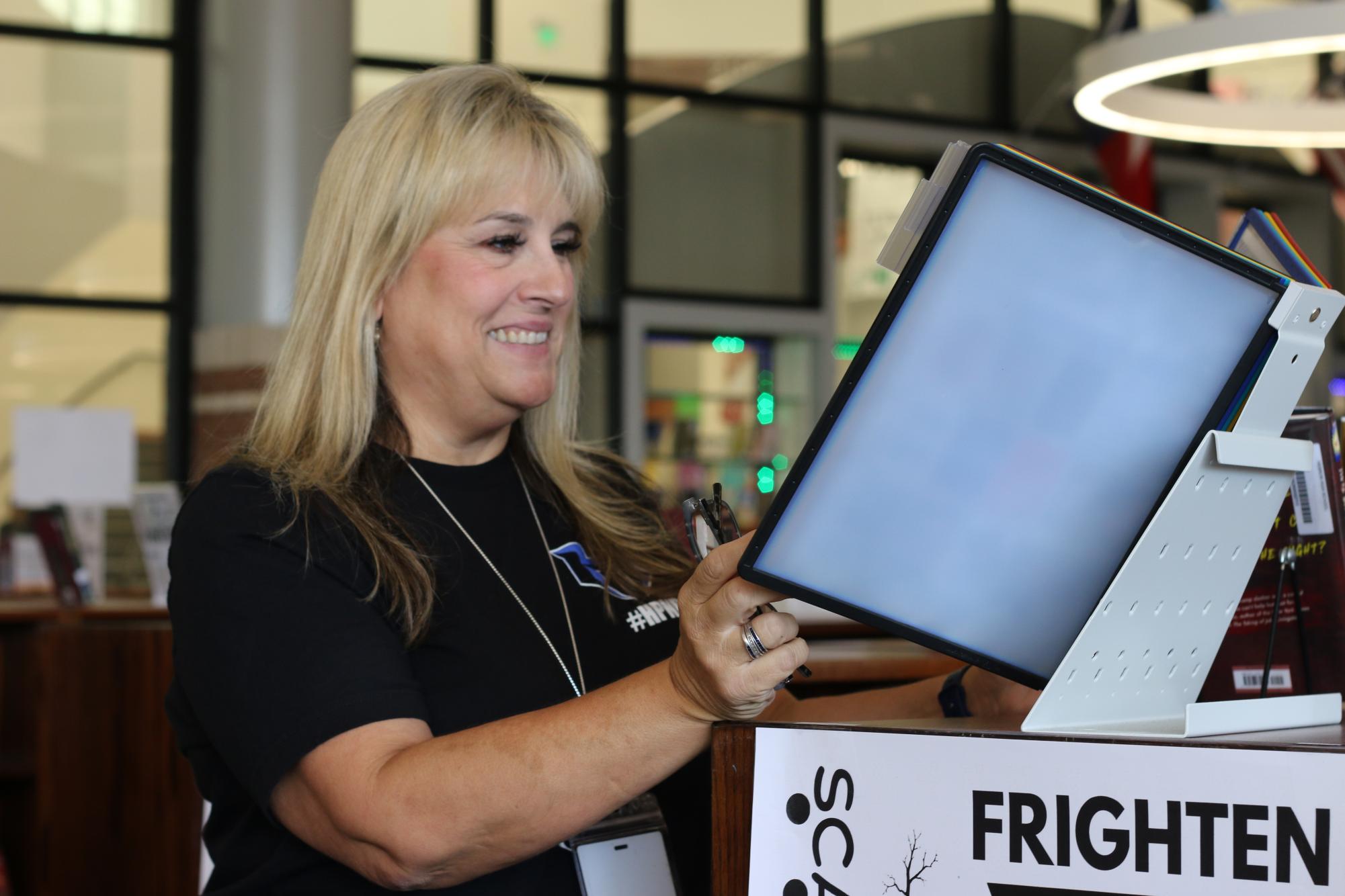 Librarian Deborah Zeman flips through a folder of book recommendations that she put together for students. She is new at the school after working at Hedrick Middle School for the last three years.