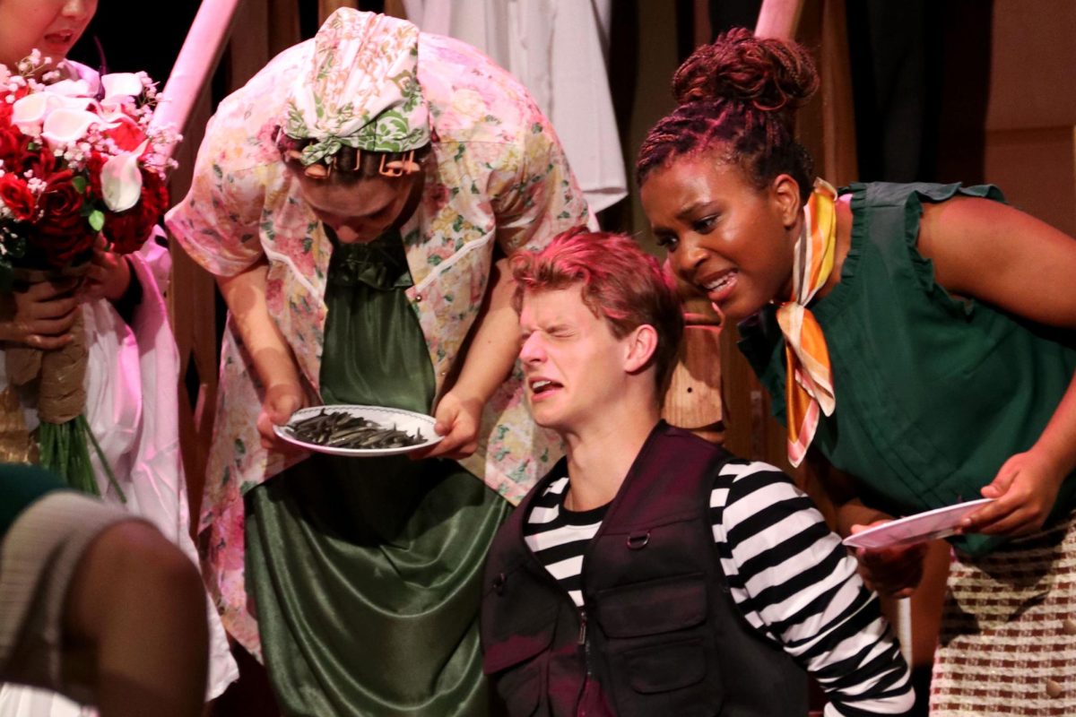 Junior Elyse Brown (left) and seniors Shane Duggan and Maya Ware perform a scene during the finale. Brown holds a plate of sardines, which consistently gets misplaced and brought up throughout the show. 