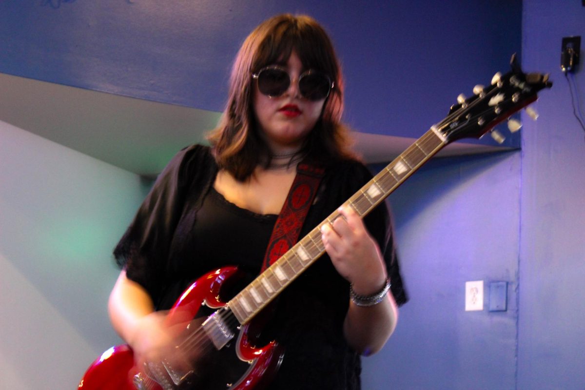 Senior Ashlyn Eggleston plays lead guitar near the end of a fundraising show at “Outta Bounds” on Sept. 14. Her band, “Liar Liar,” played this show to raise funds and support for their trip to Los Angeles.