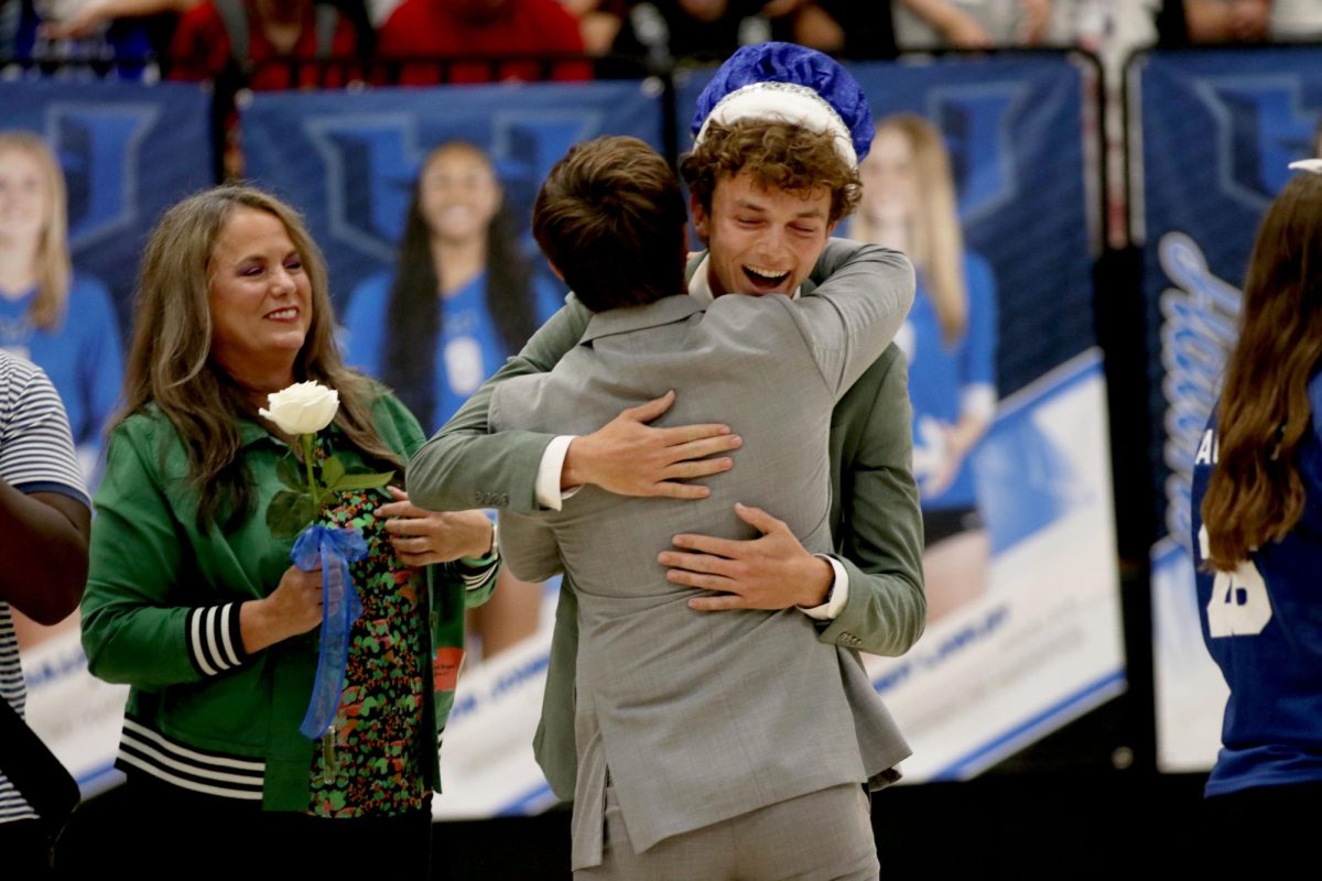 Senior Adam Vorhaben hugs 2023 Homecoming King Wesley Winkler after being crowned Homecoming King. Both were nominated by band.