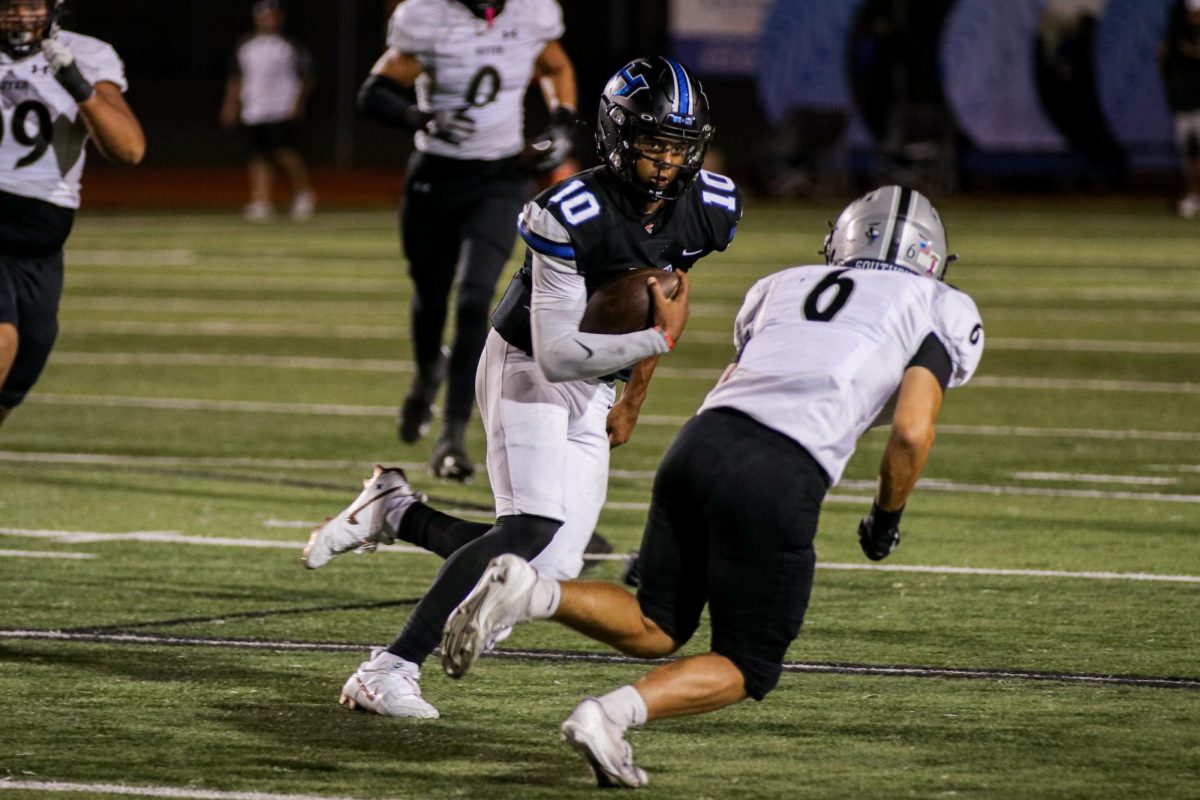 Quarterback PJ Crayton stares down a Guyer defender during a run in the team’s game on Oct. 11. The team sits at fourth place in district after starting the season off 2-2. 