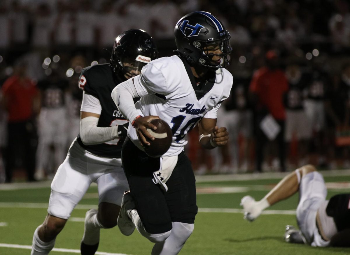 Quarterback PJ Crayton scrambles away from a Coppell defender during the team’s Sept. 27 game against Coppell. The team ended up losing the game with a final score of 49-14.