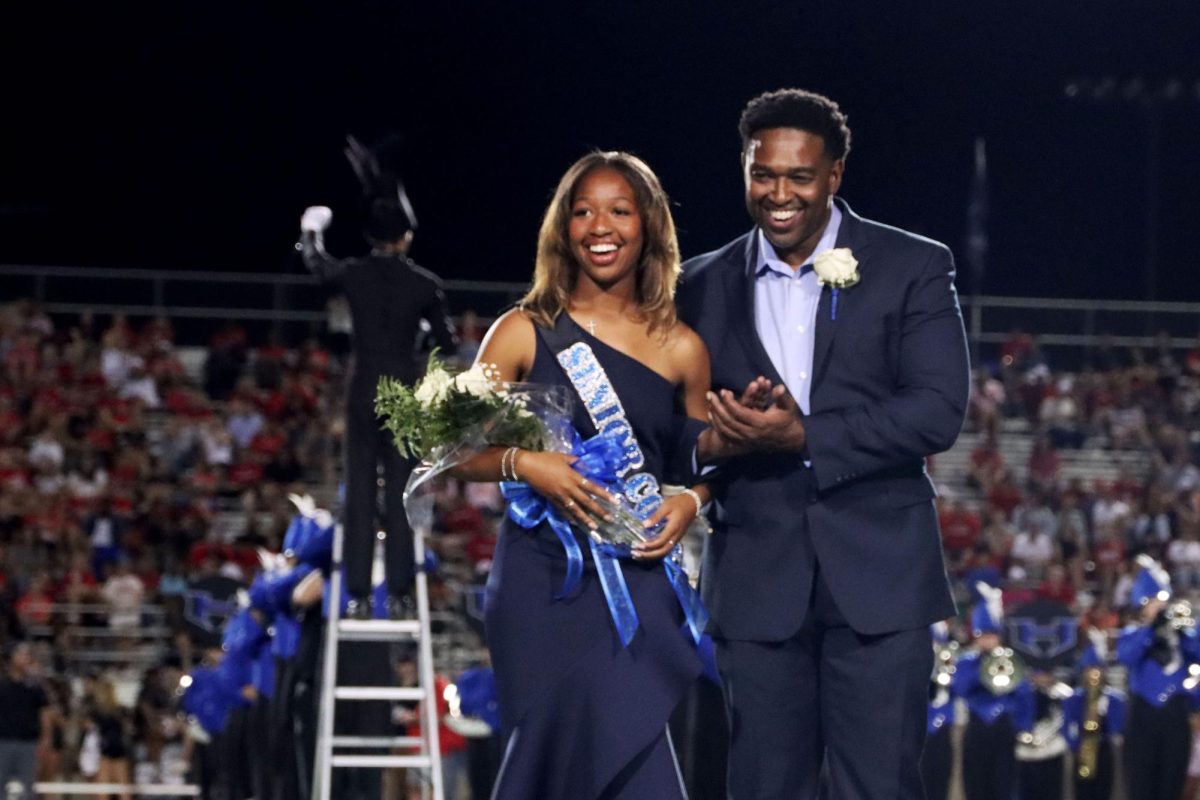 Senior Layla Thompson walks with her dad on Oct. 4 after being crowned Homecoming Queen. She was nominated by girls soccer. 