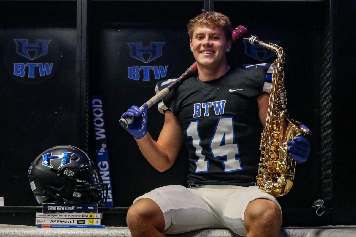 Senior Luke Sharp poses with his saxophone, bat, helmet and AP textbooks. Sharp is a member of the varsity football and baseball teams, a part of a nationally recognized saxophone quartet and a scholar. He said his interests have led to him growing as a leader and becoming a better person through them.