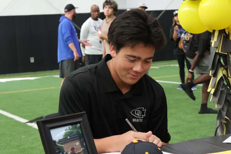 Baseball player Quinn Bergman signs his contract during signing day on Nov. 13. He officially committed to the Ottawa University following his verbal commitment on Oct. 22. (Photo provided by Quinn Bergman)
