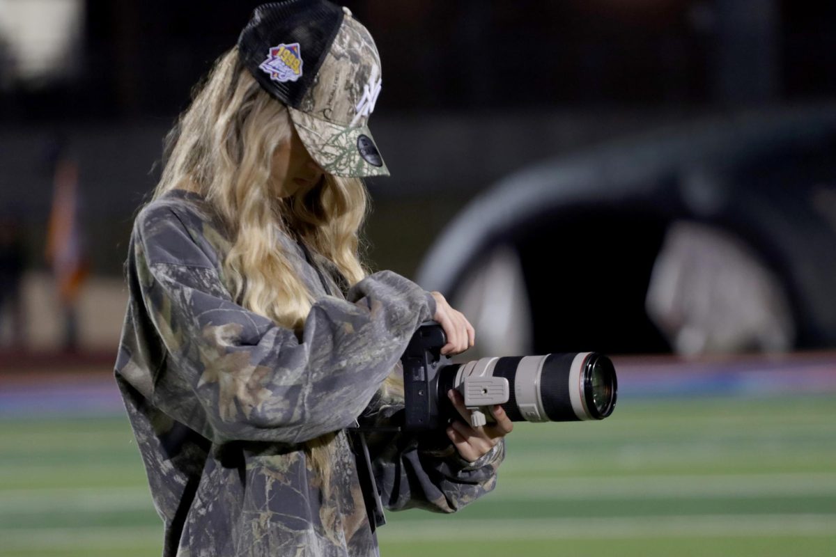  Senior Hailey Yoon takes a photo from the sidelines of the football game vs Bowie on Nov. 22. This is Yoon’s second season taking photos of football after starting her business. 