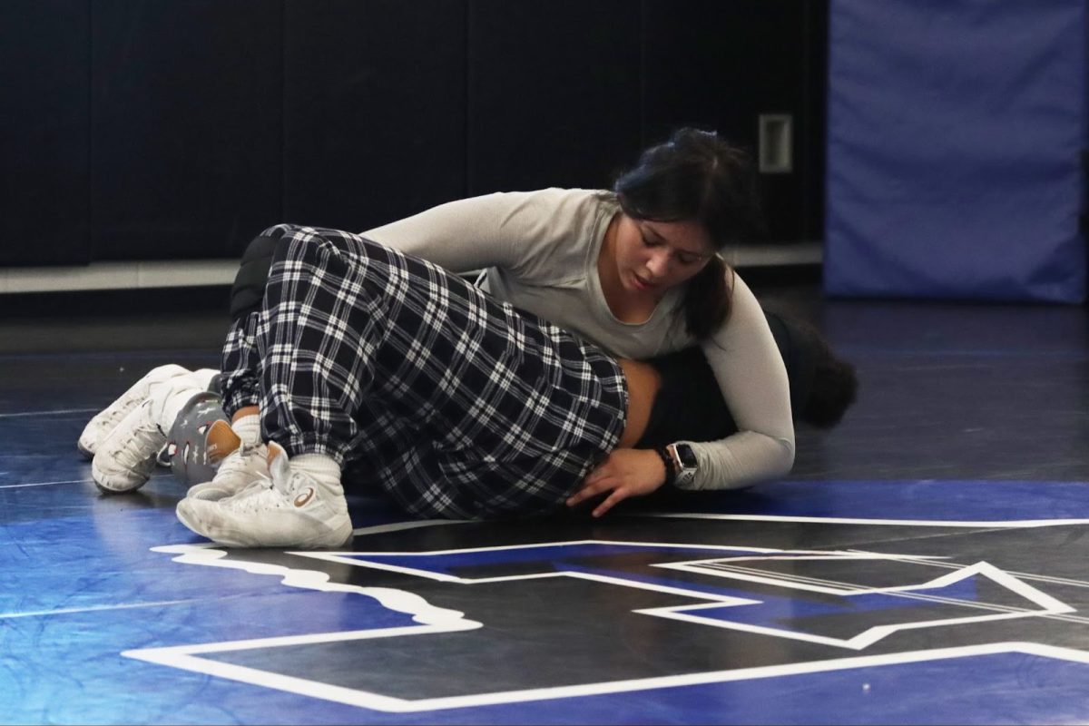 Junior Jaidy Canacho tackles freshman Taylor Dogans during practice on Dec. 11. In preparation for the upcoming tournament, the team has been working on offensive tackles, including attacking from on top. 