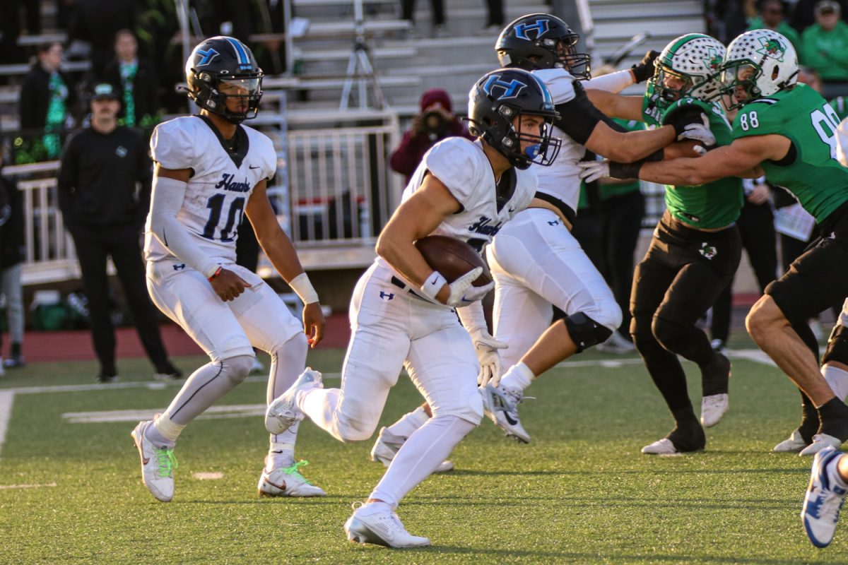 Wide receiver Drew Koster runs the ball during the team’s regional semifinal playoff game against Southlake Carroll on Nov. 29. The Hawks lost the game with a final score of  42-37, and equaled their best finish since 2018.