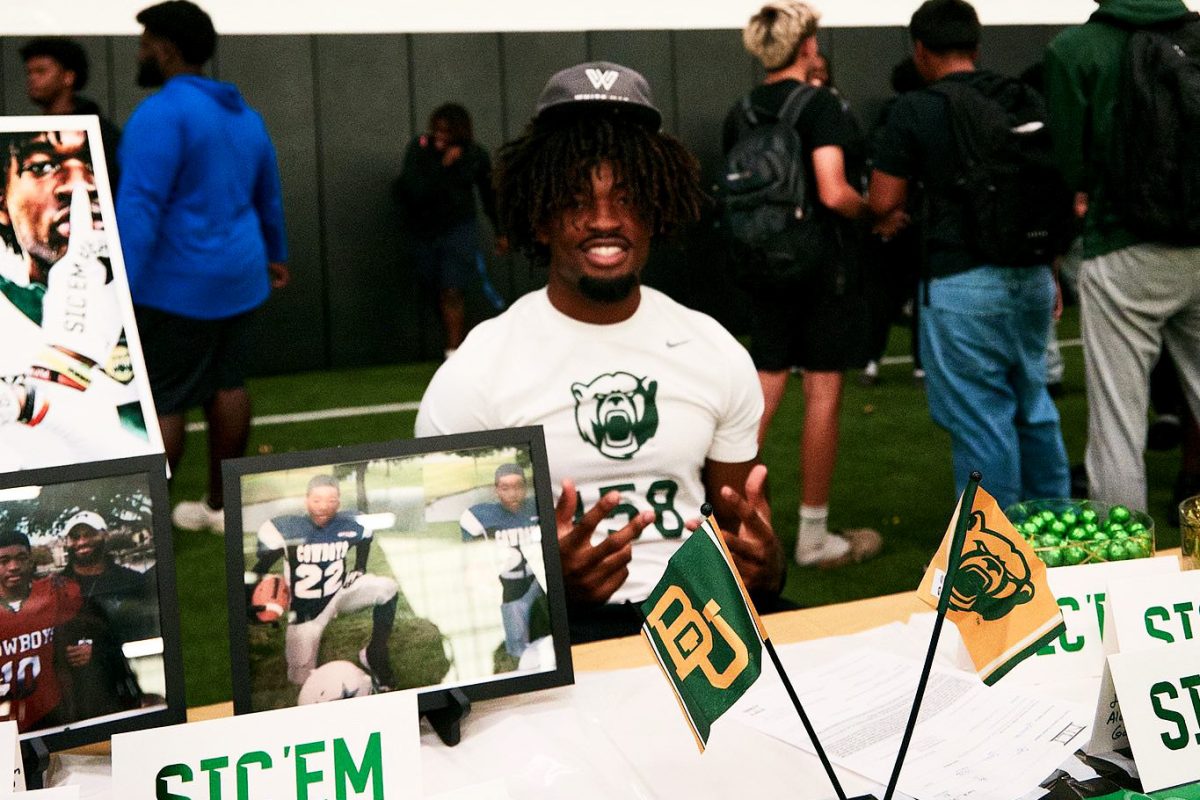 Football player Bo Onu sits behind his table on signing day after signing his contract on Nov. 13. He made his verbal commitment on June 17. (Photo provided by Bo Onu)